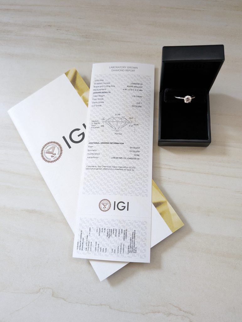 Our diamond ring beside its IGI laboratory-grown diamond report