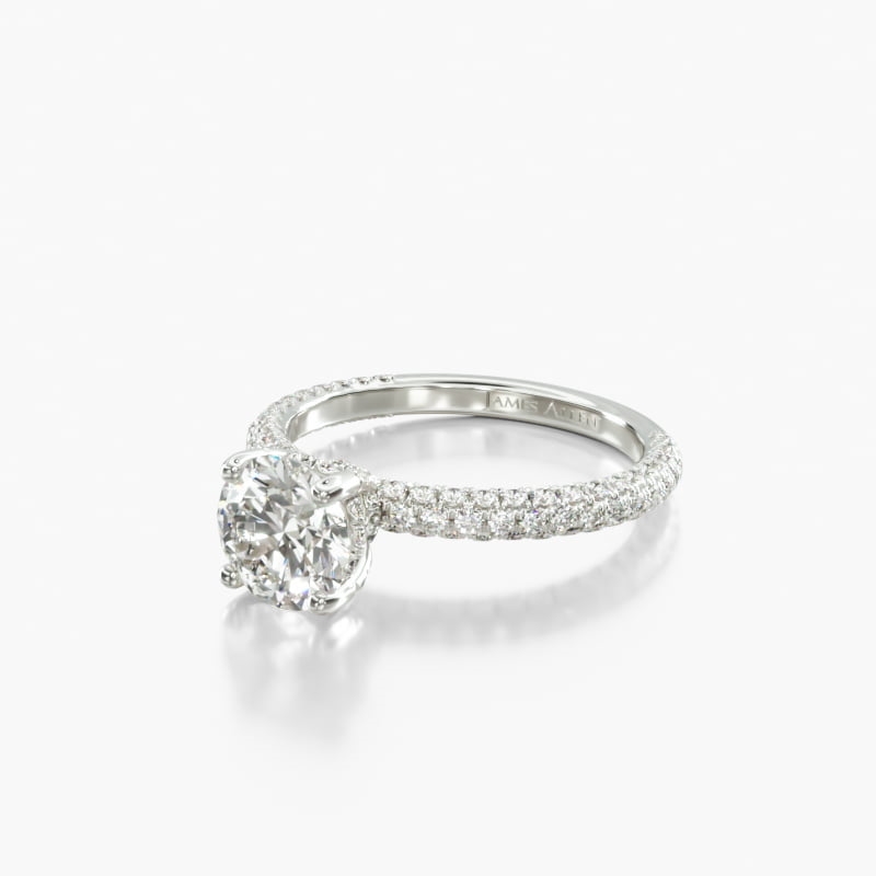 Round diamond in a white-metal cathedral ring with diamond-set shoulders