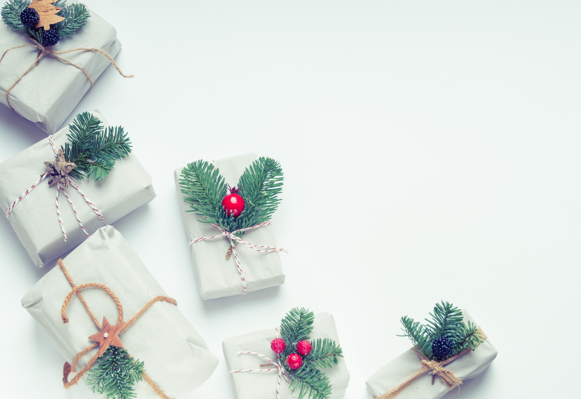 Wrapped Christmas gifts with evergreen sprigs and red berries