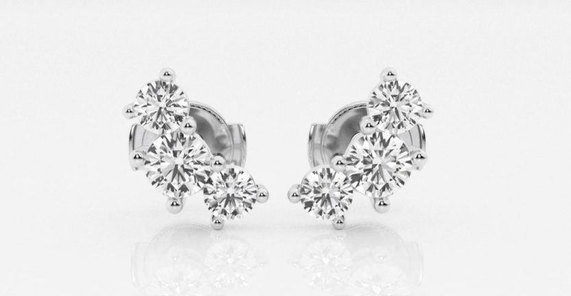 Three round diamonds in a curved row on each white-metal stud