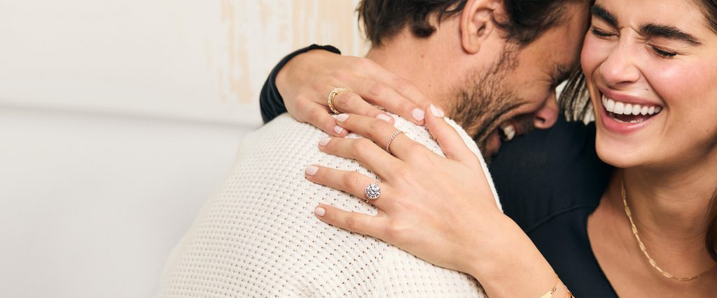 Woman showing a diamond engagement ring in the original James Allen guide