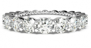 White-metal eternity band with larger round diamonds in shared prongs