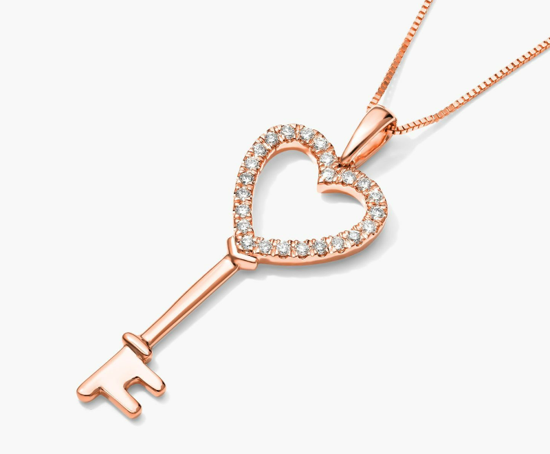Rose-gold key pendant with a diamond-set open heart at the top