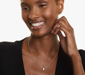 Model wearing a small emerald-cut diamond solitaire necklace