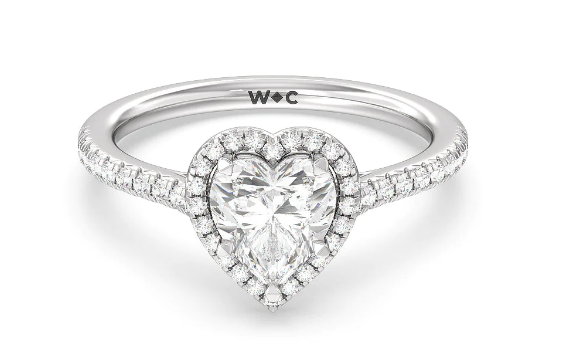 Heart-cut diamond with a halo and diamond-set shoulders on a white-metal cathedral ring