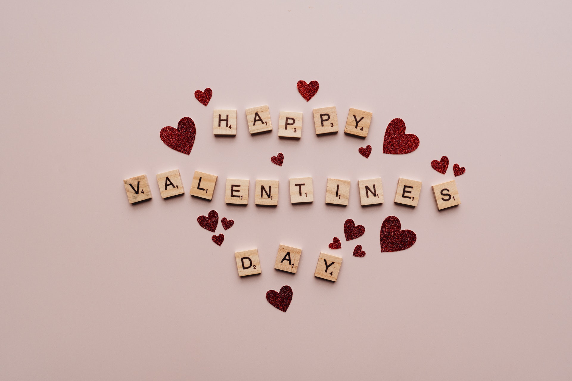 Happy Valentine's Day letter tiles surrounded by small red hearts