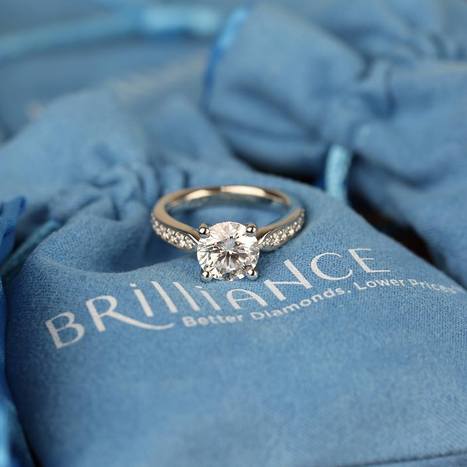 Diamond engagement ring displayed on a blue Brilliance jewellery pouch