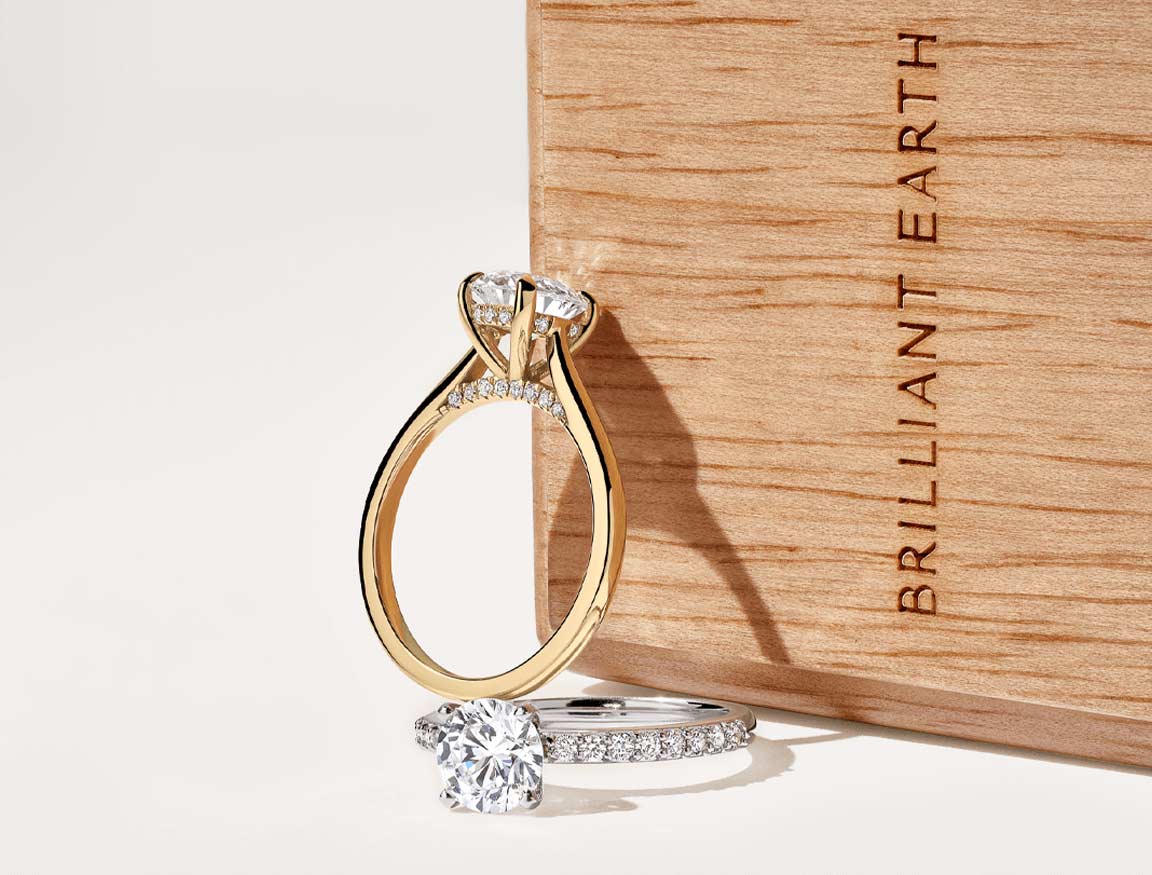 Brilliant Earth diamond rings beside a wooden Brilliant Earth ring box