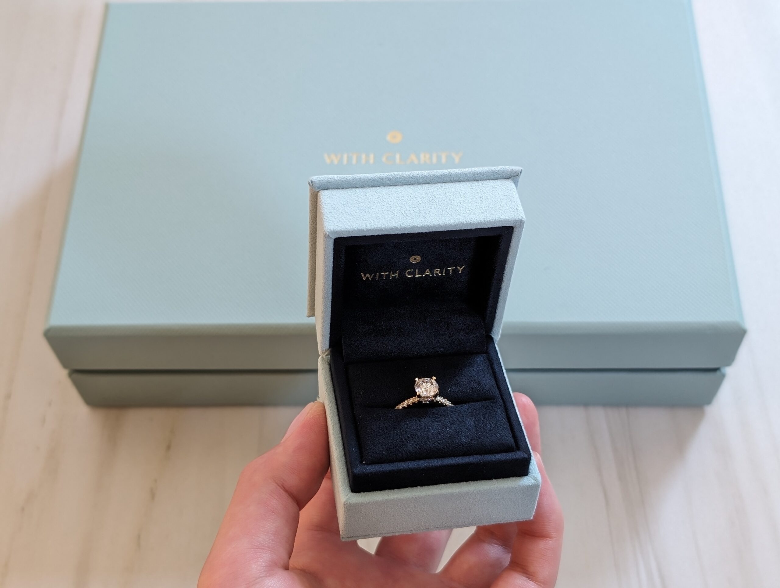 With Clarity lab-grown diamond engagement ring in its blue presentation box