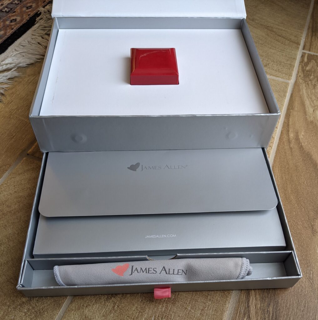 James Allen jewelry box displaying an engagement ring inside the brand’s signature packaging.